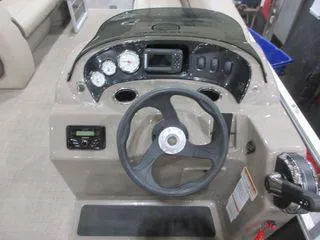 Slide: The Image of 2023 Sun Tracker Party Barge 18 DLX dashboard with steering wheel and control panel. - 3