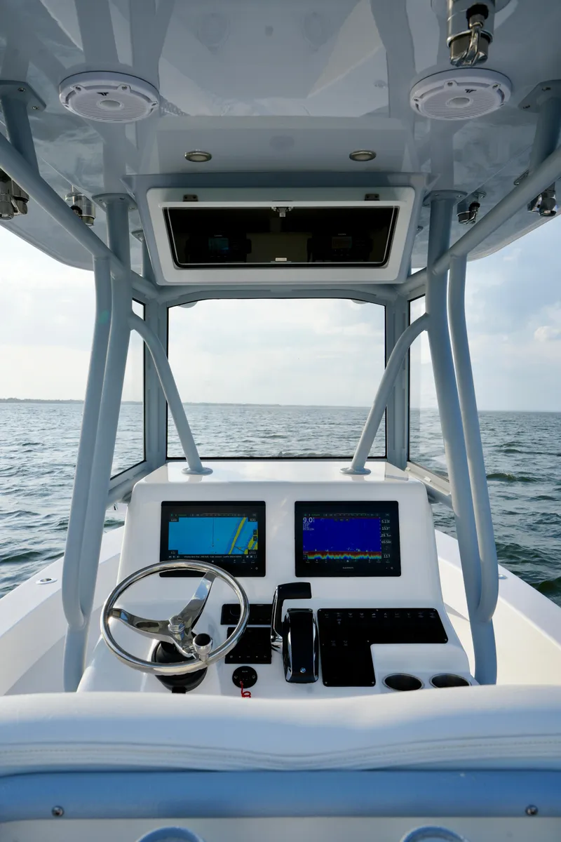 Slide: The Image of 2024 Reef Runner 230 Open boat console with dual navigation screens on open water. - 21