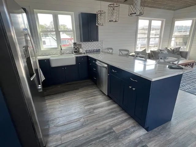 Slide: The Image of Modern kitchen in 2020 Harbor Cottage houseboat, featuring navy cabinets and stainless steel appliances. - 10