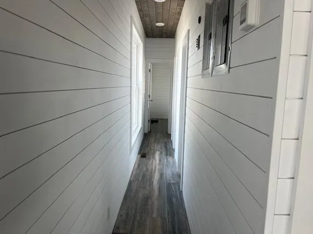 Slide: The Image of Narrow hallway in 2020 Harbor Cottage model 16 x 84 with white shiplap walls and wood flooring. - 13