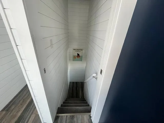 Slide: The Image of Staircase in a 2020 Harbor Cottage 16 x 84 model with white shiplap walls. - 14
