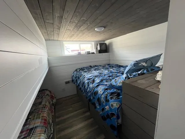 Slide: The Image of Cozy bedroom in 2020 Harbor Cottage 16 x 84 with wooden ceiling and colorful bedding. - 16