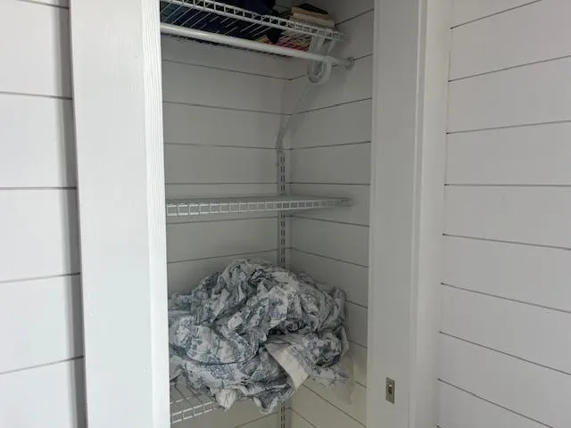 Slide: The Image of White shiplap closet with wire shelves and crumpled fabric, Harbor Cottage 16 x 84, 2020 model. - 18