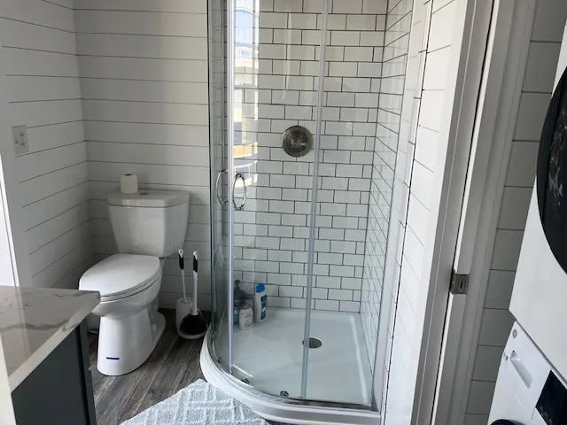 Slide: The Image of Modern bathroom with glass shower, white subway tiles, and wood flooring in a Harbor Cottage 16 x 84. - 20
