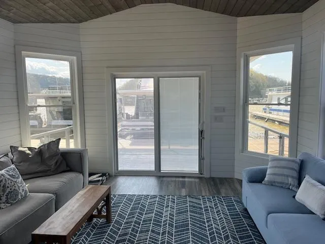 Slide: The Image of Modern living room in a 2020 Harbor Cottage 16 x 84 houseboat, featuring large windows and cozy seating. - 9