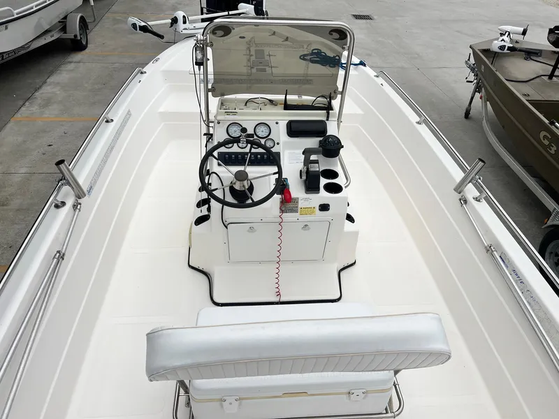 Slide: The Image of 2001 Skeeter ZX 2200 boat interior with steering console and seating, docked in a marina. - 9