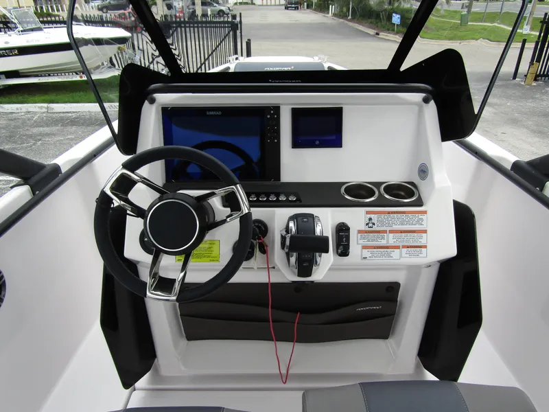 Slide: The Image of 2022 Axopar 22 T-Top boat dashboard with steering wheel, controls, and display screens. - 13