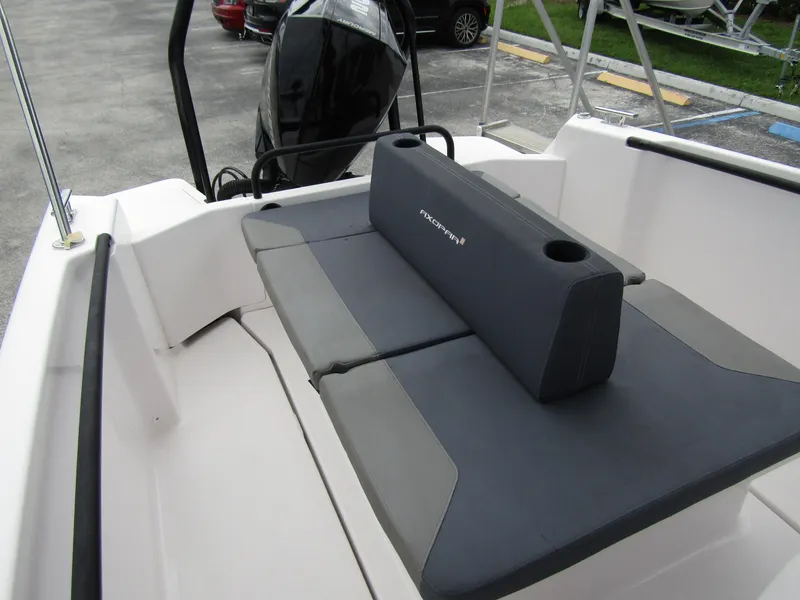 Slide: The Image of 2022 Axopar 22 T-Top boat interior with cushioned seating and motor view. - 19