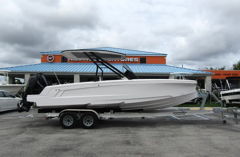 Slide: The Image of 2022 Axopar 22 T-Top boat on trailer, parked outside a dealership. - 3