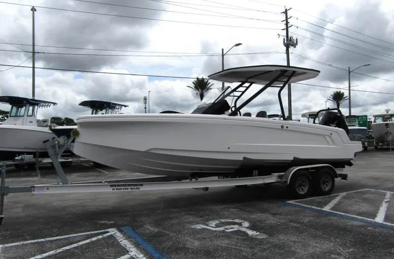 Slide: The Image of 2022 Axopar 22 T-Top boat on trailer, parked in a lot under cloudy skies. - 5
