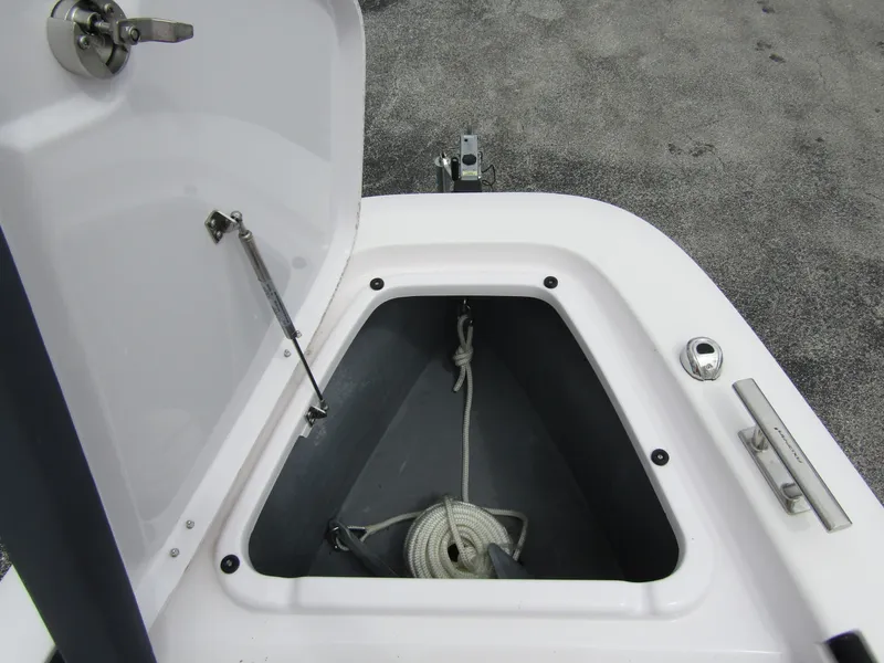 Slide: The Image of Anchor storage compartment on 2022 Axopar 22 T-Top boat, featuring secure latch and rope. - 7