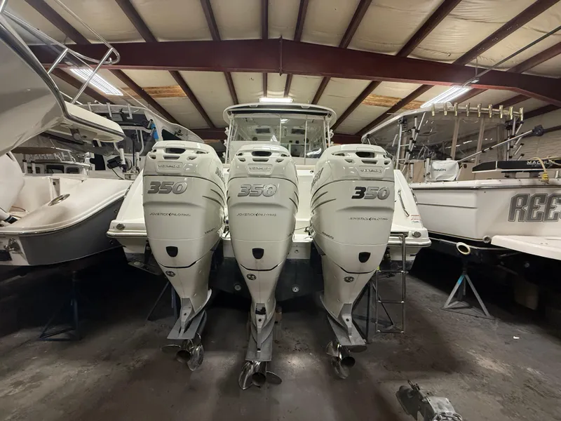 Slide: The Image of 2018 Boston Whaler 345 Conquest with triple 350 horsepower engines in a storage facility. - 1