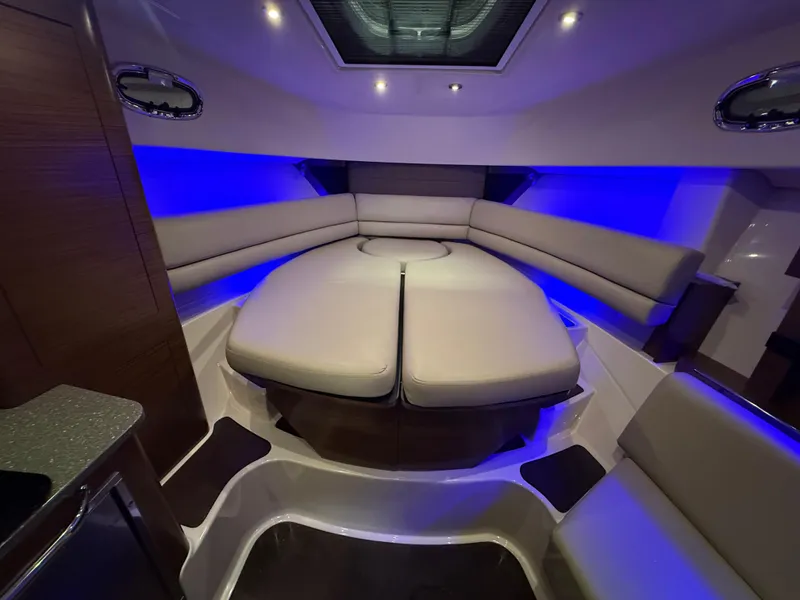 Slide: The Image of 2018 Boston Whaler 345 Conquest cabin with modern seating and ambient blue lighting. - 16