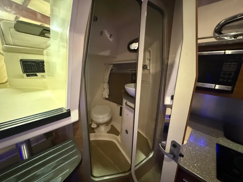 Slide: The Image of Interior of 2018 Boston Whaler 345 Conquest showing compact bathroom with toilet and sink. - 22