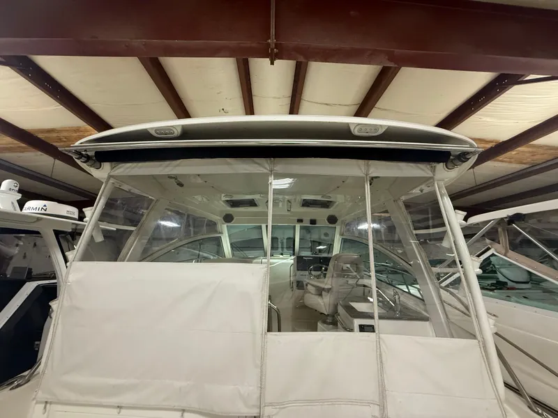 Slide: The Image of 2018 Boston Whaler 345 Conquest boat interior, stored indoors, showcasing helm and seating area. - 7