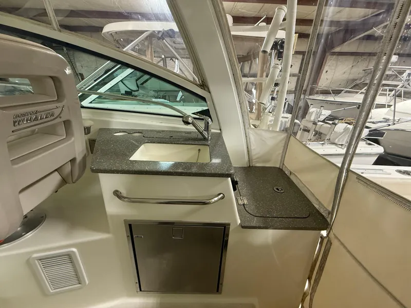 Slide: The Image of 2018 Boston Whaler 345 Conquest interior with sink and counter in a boat cabin. - 9