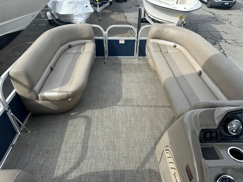 Slide: The Image of 2023 Ranger Reata 200C pontoon boat interior with beige seating and carpeted floor. - 17
