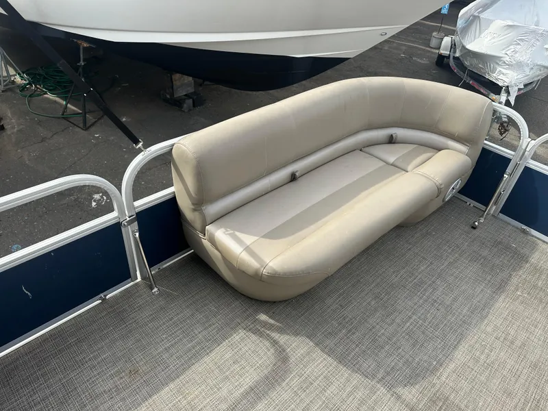Slide: The Image of 2023 Ranger Reata 200C pontoon boat with beige seating and metal railings. - 18