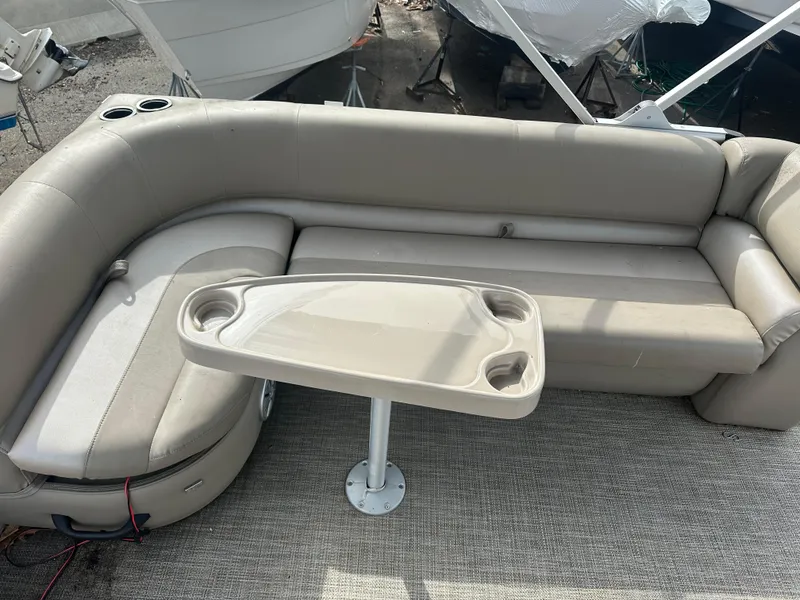 Slide: The Image of 2023 Ranger Reata 200C boat interior with beige seating and table. - 9