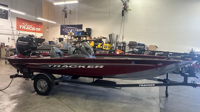 Slide: The Image of 2020 Tracker PRO175TXW boat in a workshop, featuring a sleek red design and Mercury engine. - 3