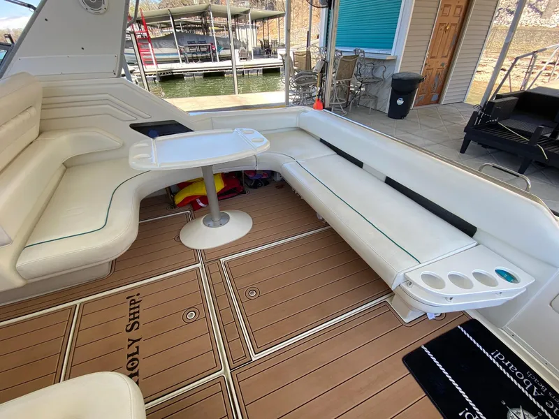 Slide: The Image of 1995 Sea Ray 400 Express Cruiser interior with white seating and wooden deck. - 10