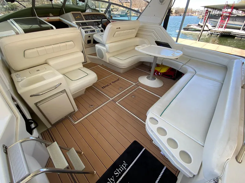 Slide: The Image of 1995 Sea Ray 400 Express Cruiser interior with white seating and wooden flooring. - 11