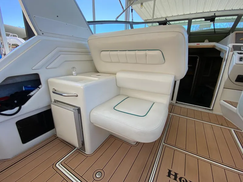 Slide: The Image of 1995 Sea Ray 400 Express Cruiser interior with white seating and wood flooring. - 15