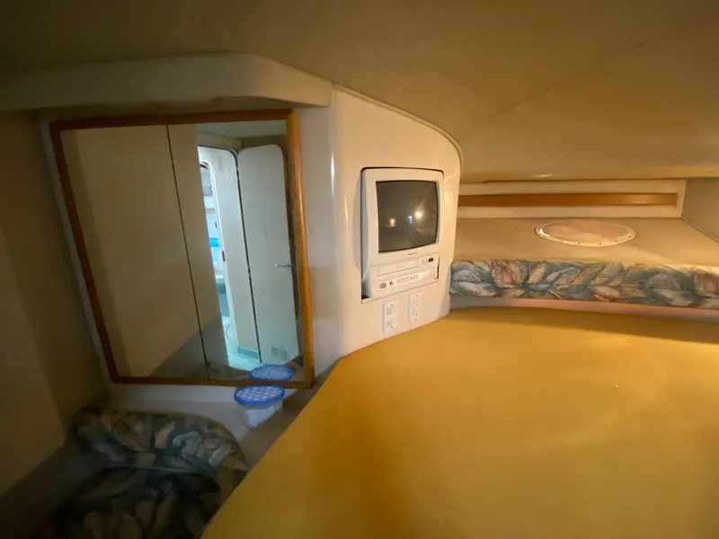 Slide: The Image of Interior of 1995 Sea Ray 400 Express Cruiser with TV, mirror, and cozy bedding. - 21