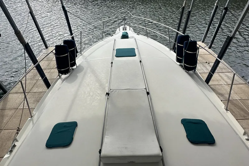 Slide: The Image of 1995 Sea Ray 400 Express Cruiser deck with teal cushions, docked by the water. - 4