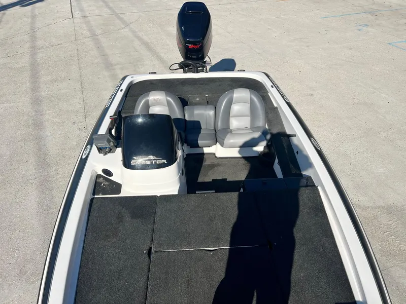 Slide: The Image of 2007 Skeeter ZX 190 boat interior with dual seats and motor, parked on concrete surface. - 6