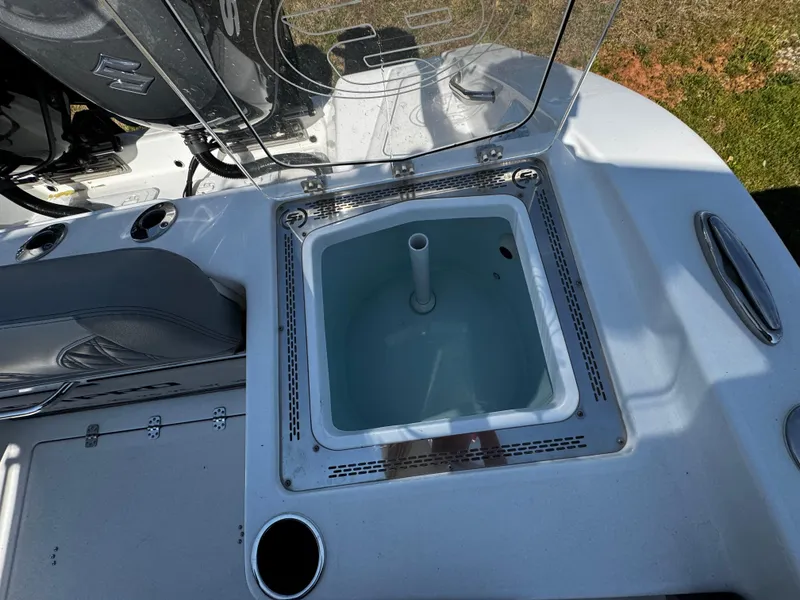 Slide: The Image of 2023 Sea Pro 320 DLX Center Console livewell with open lid, showcasing interior features. - 10