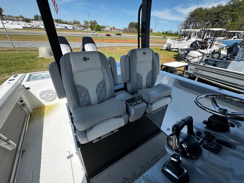 Slide: The Image of 2023 Sea Pro 320 DLX Center Console boat interior with dual captain seats and steering controls. - 11