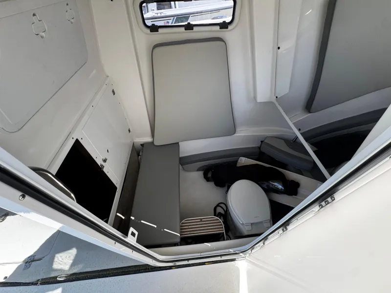 Slide: The Image of 2023 Sea Pro 320 DLX Center Console cabin interior with seating and storage. - 12
