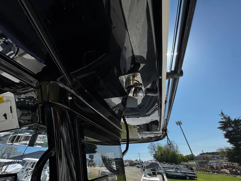 Slide: The Image of 2023 Sea Pro 320 DLX Center Console boat detail with sleek black finish under sunny sky. - 16