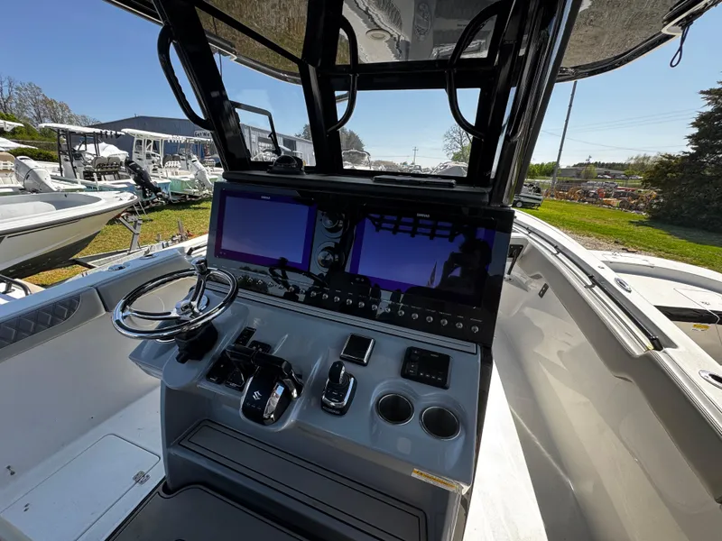 Slide: The Image of 2023 Sea Pro 320 DLX Center Console boat with advanced navigation controls and dual screens. - 7