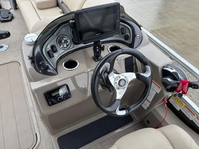 Slide: The Image of 2022 Sun Tracker SportFish 22 XP3 dashboard with steering wheel and navigation display. - 18