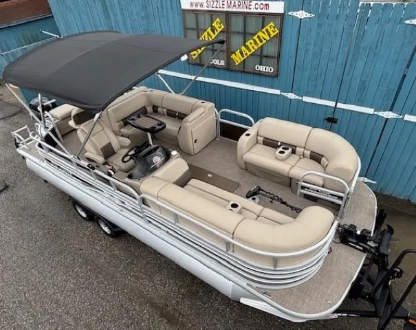 Slide: The Image of 2022 Sun Tracker SportFish 22 XP3 pontoon boat with beige seating and canopy, parked outdoors. - 6