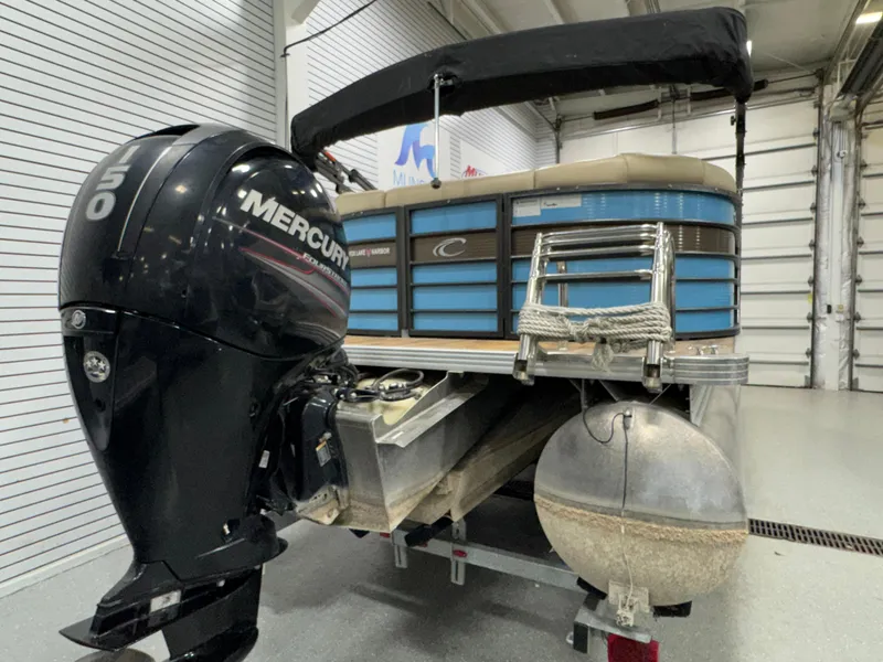 Slide: The Image of 2019 Crest III 240 SLE pontoon boat with Mercury outboard motor in a garage setting. - 18