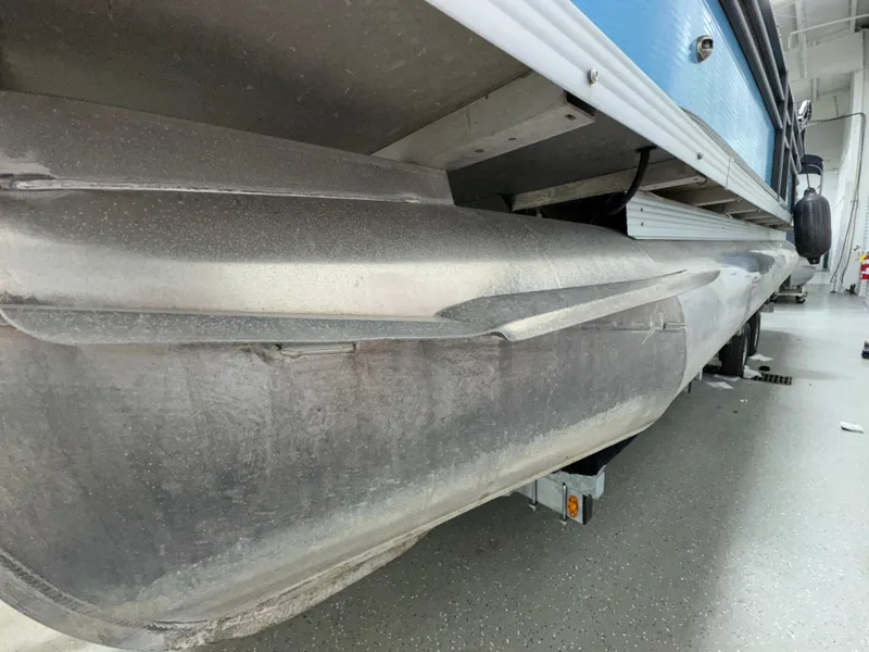 Slide: The Image of 2019 Crest III 240 SLE pontoon boat underside view in a garage setting. - 20