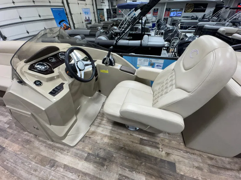 Slide: The Image of 2019 Crest III 240 SLE boat interior with beige captain's chair and steering console. - 30