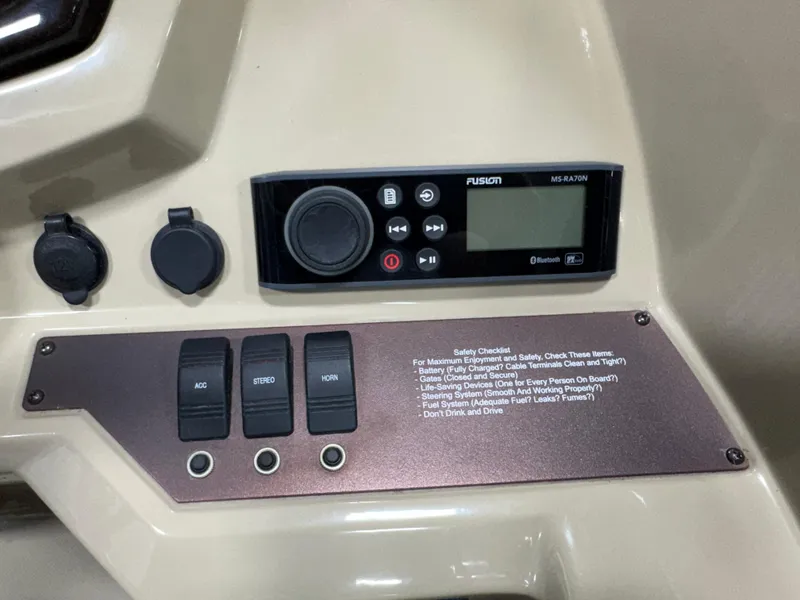 Slide: The Image of Control panel of a 2019 Crest III 240 SLE boat with audio system and switches. - 35