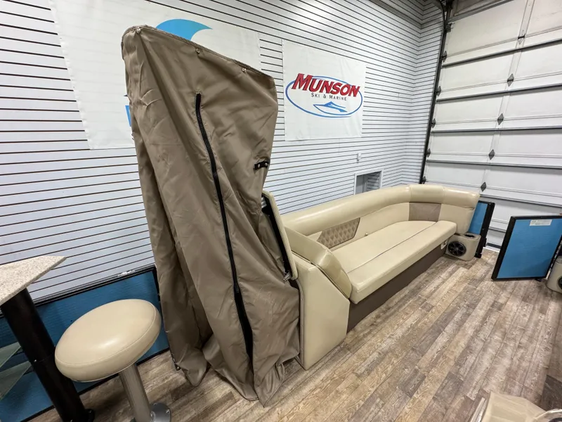 Slide: The Image of 2019 Crest III 240 SLE boat interior with beige seating and cover in showroom. - 37