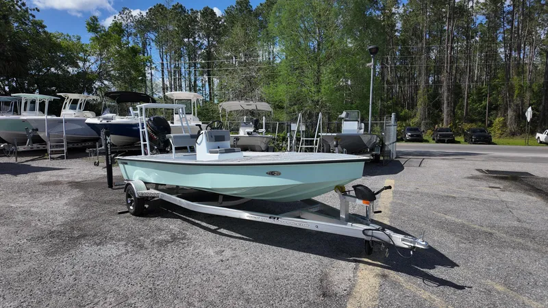 Slide: The Image of 2025 Xpress Skiff 185 boat on trailer in outdoor dealership lot. - 1