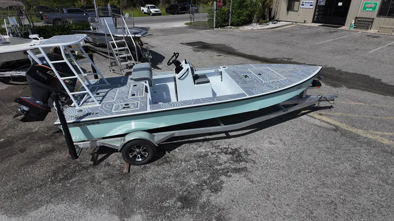 Slide: The Image of 2025 Xpress Skiff 185 boat on trailer in parking lot. - 11