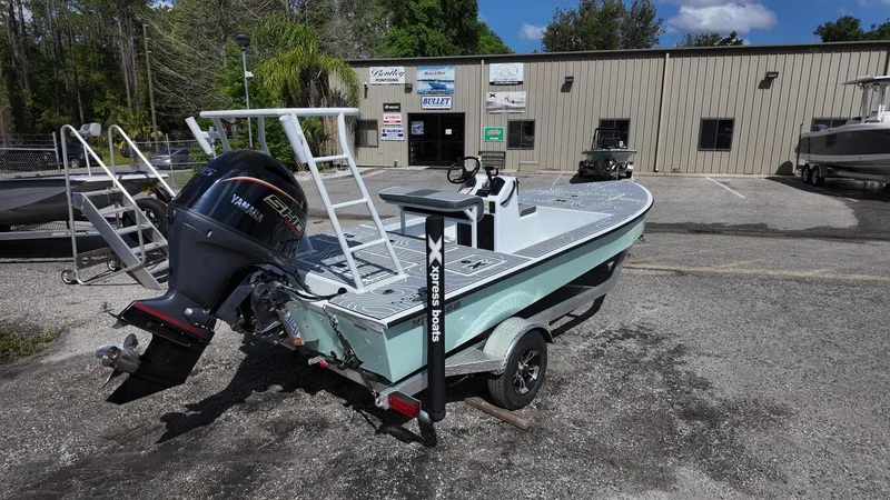 Slide: The Image of 2025 Xpress Skiff 185 boat with Yamaha outboard motor on trailer, parked outside dealership. - 16