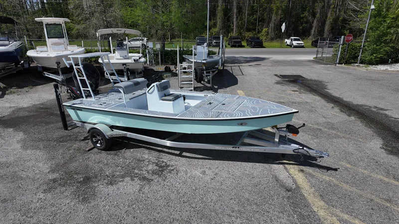 Slide: The Image of 2025 Xpress Skiff 185 boat on trailer in outdoor lot. - 5