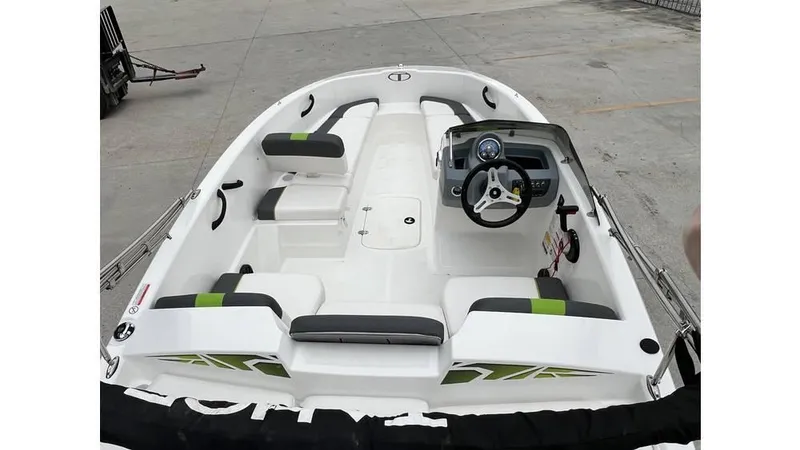 Slide: The Image of 2022 Tahoe T16 boat interior with seating and steering wheel, docked on concrete surface. - 6