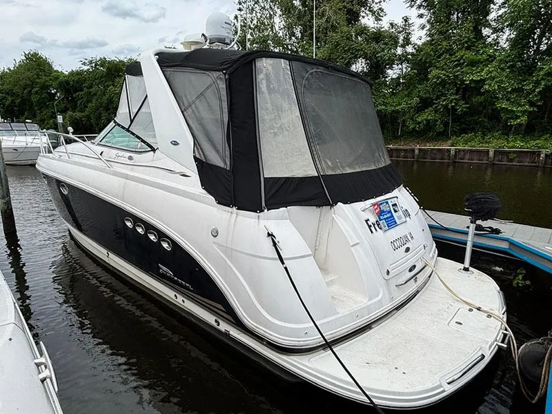 The Image of 2004 Chaparral 350 Signature boat docked, featuring sleek design and black canopy. - 0