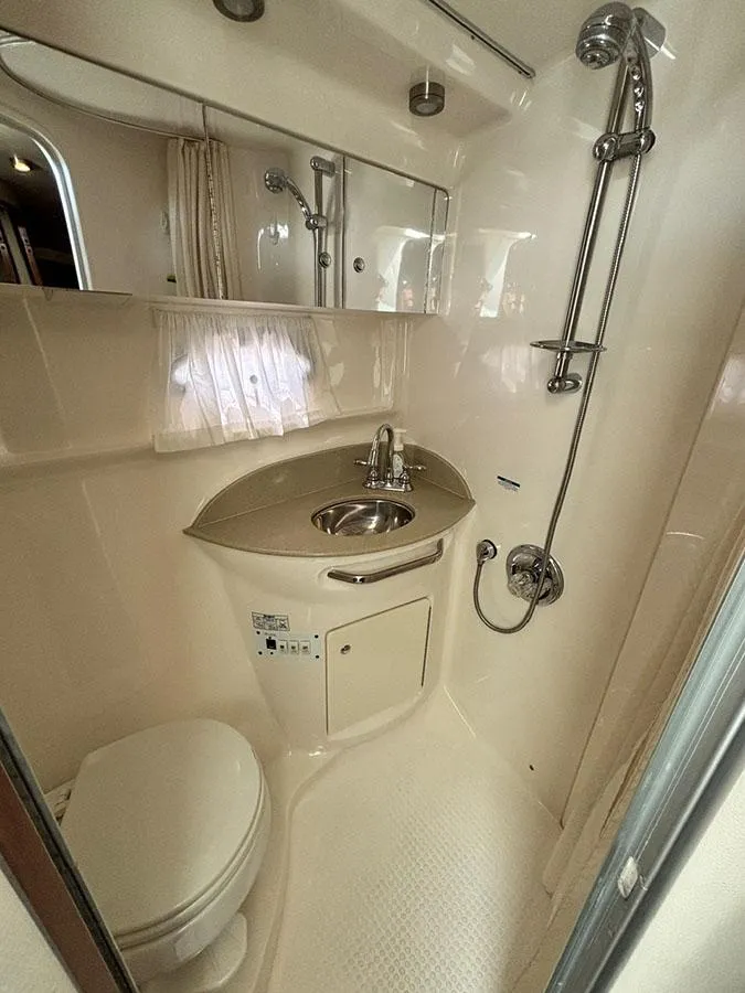 Slide: The Image of 2004 Chaparral 350 Signature boat bathroom with shower, sink, and toilet. - 11