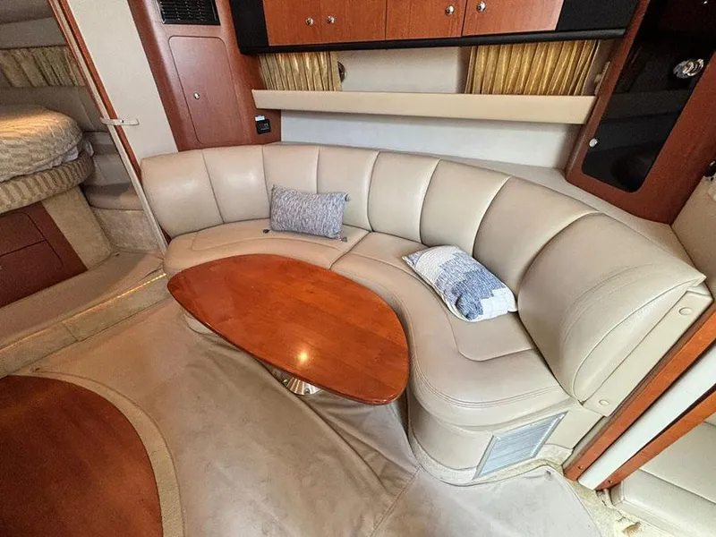 Slide: The Image of 2004 Chaparral 350 Signature interior with curved leather seating and wooden table. - 15